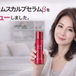 オーリムスカルプセラムβを手に持ちレビューする50代女性のイメージ写真